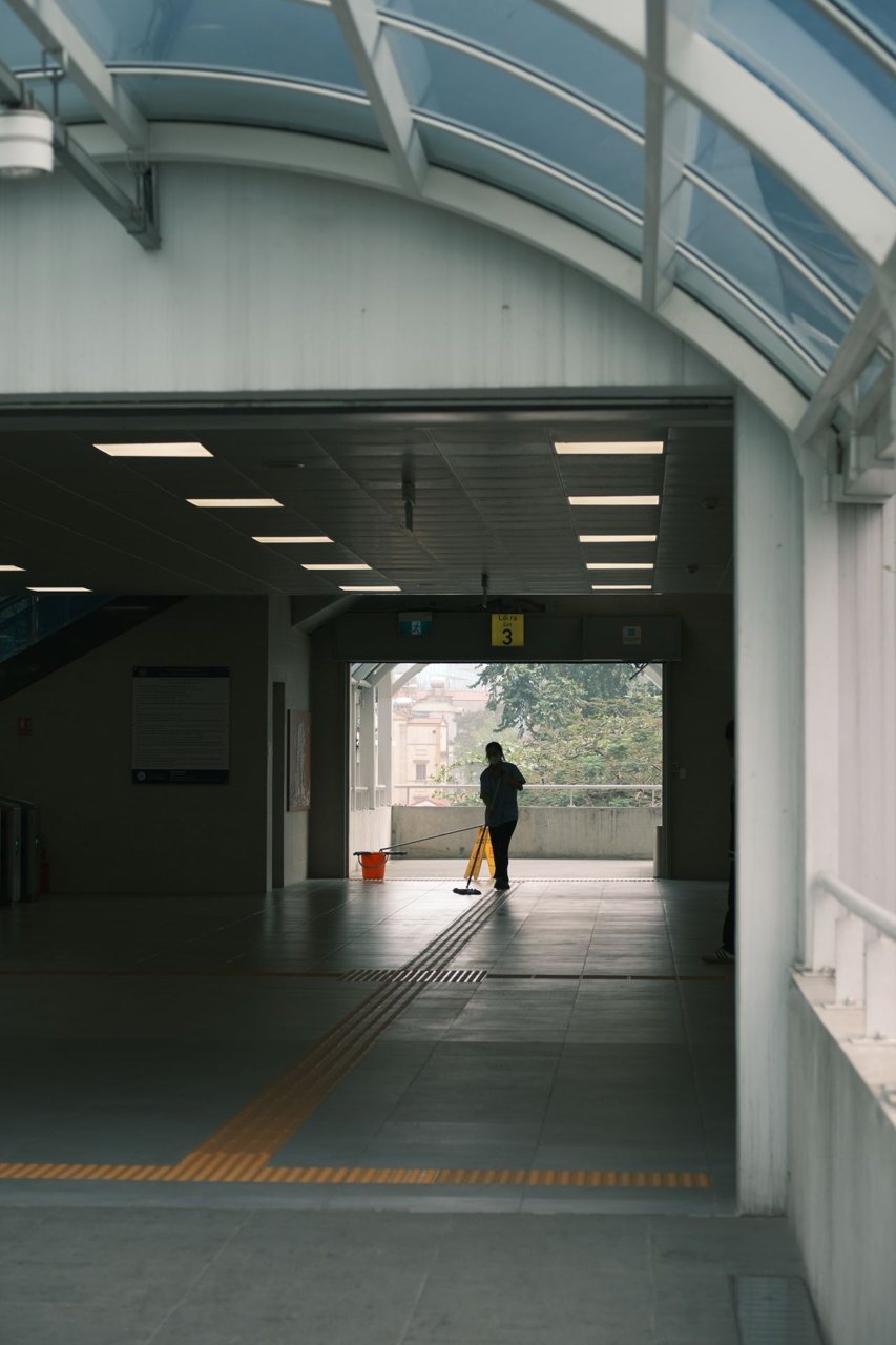 Free A solitary janitor cleans a quiet subway’s open walkway. Stock Photo